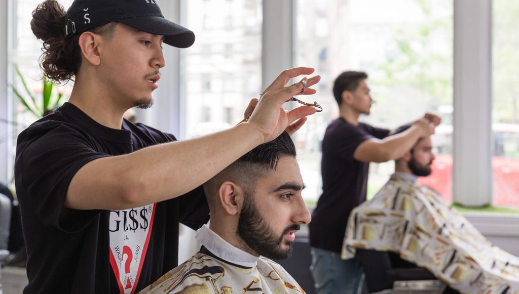 Pivot Point barber cuts a client's hair