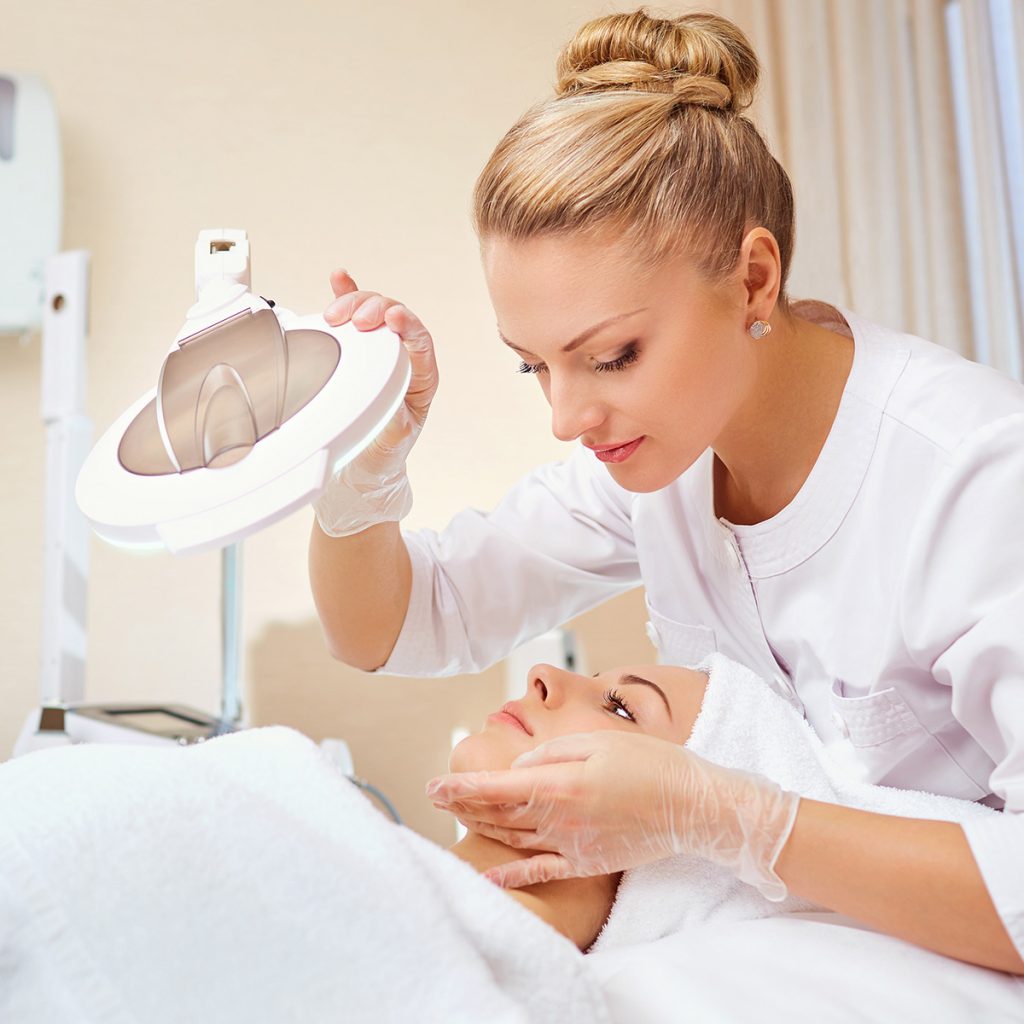Pivot Point esthetician analyzing client's skin