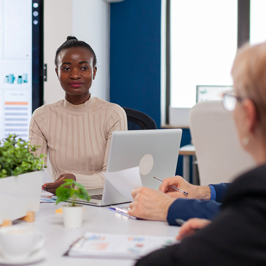 Ethnic executive management planning business plan sitting in boardroom conference meeting. Businesswoman discussing ideas with colleagues about financial strategy for new start up company.