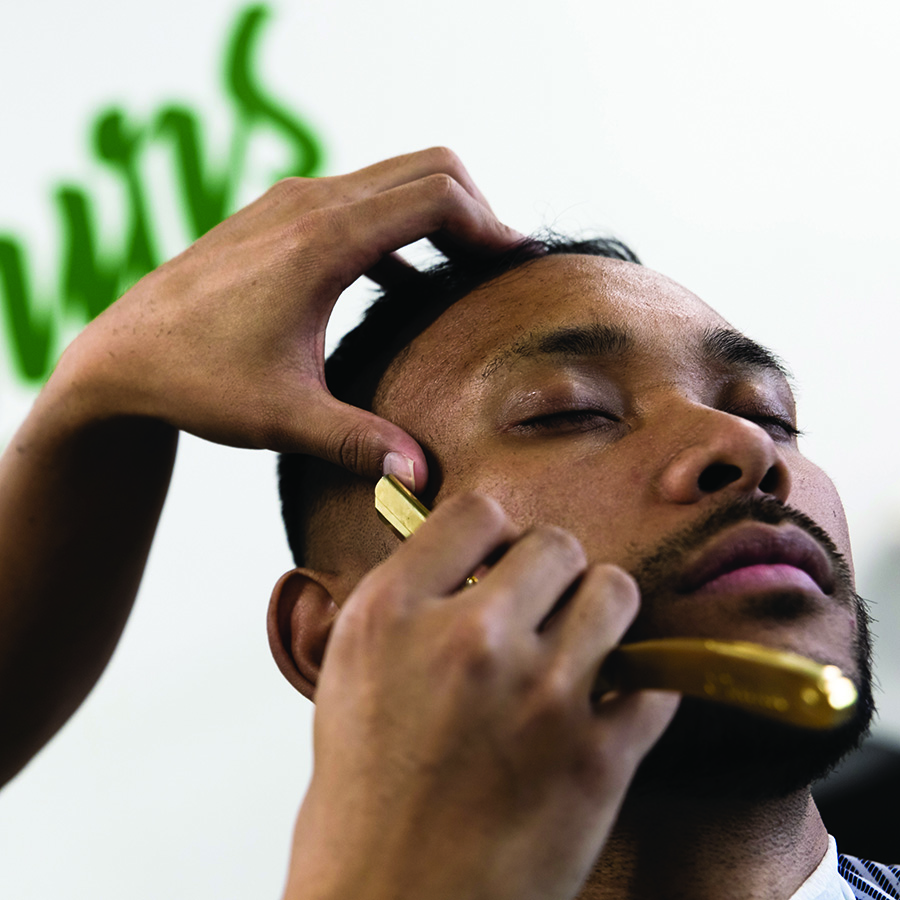 Close up of shaving hair with male customer