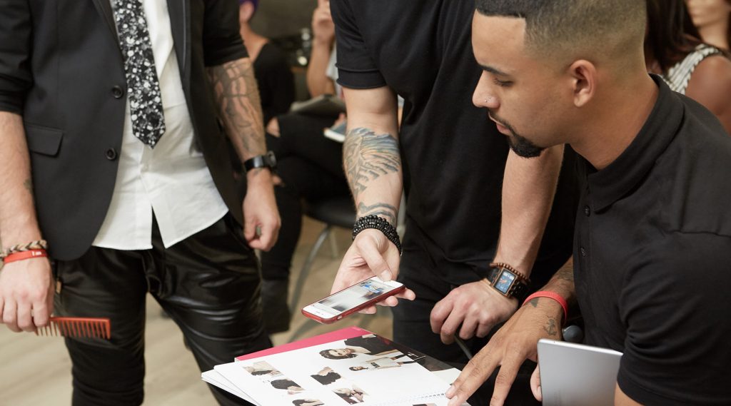 Pivot Point instructor showing students how to watch trend workshops by scanning codes on trend books
