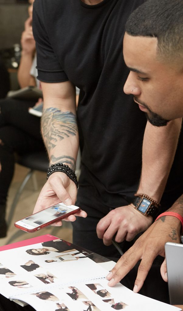 Pivot Point instructor showing students how to watch trend workshops by scanning codes on trend books