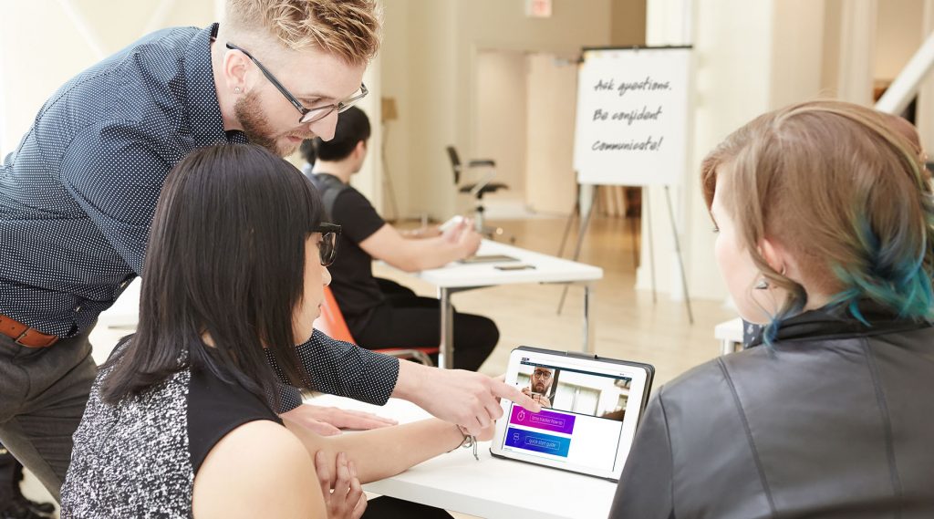 Pivot Point instructor and students reviewing LAB on a tablet